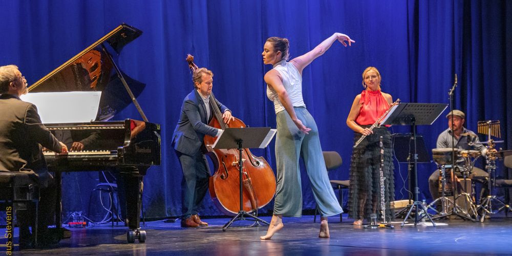 „Metamorphosen“ mit Eleanor Freeman und dem Maiburg Ensemble Eine Tänzerin auf der Bühne, dahinter eine Querflötistin und ein Klaviertrio